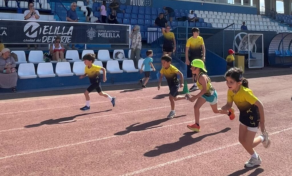 Niños corriendo en una pista de atletismo durante un torneo escolar
