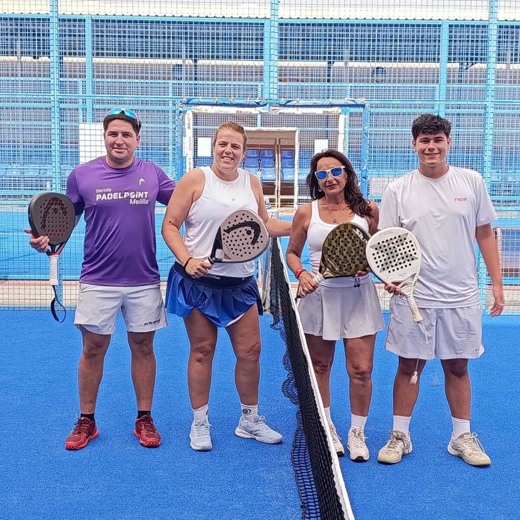 Cuatro jugadores de pádel posando en la cancha tras el torneo
