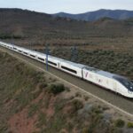 Tren de alta velocidad viajando por un paisaje montañoso en España