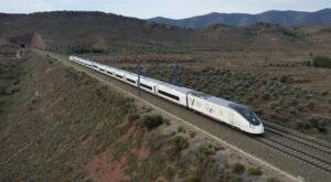 Tren de alta velocidad viajando por un paisaje montañoso en España