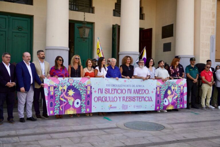 Grupo de personas sosteniendo un cartel en una celebración del orgullo LGTBI.