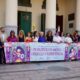Grupo de personas sosteniendo un cartel en una celebración del orgullo LGTBI.