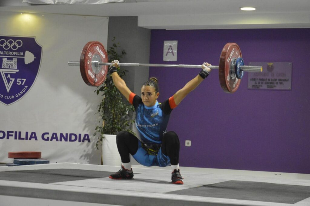 Atleta levantando pesas en competición de halterofilia.