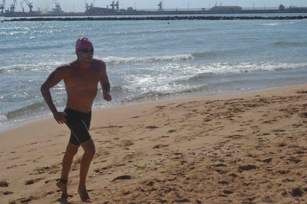 Nadador corriendo en la playa tras la Travesía a Nado de Melilla