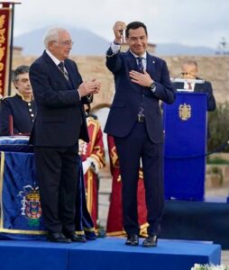 Juanma Moreno recibiendo un símbolo de posesión en un evento oficial