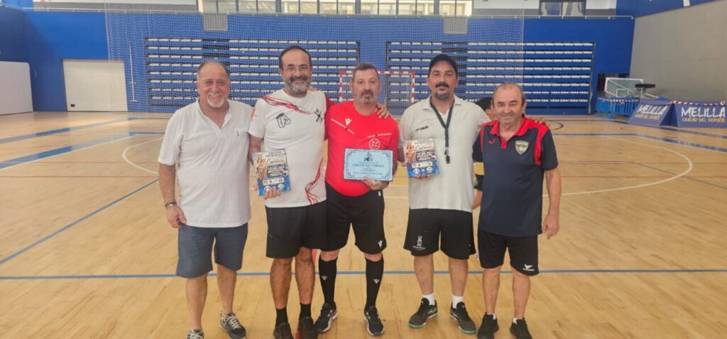 Five men stand together on an indoor sports court, holding certificates and smiling after a game.