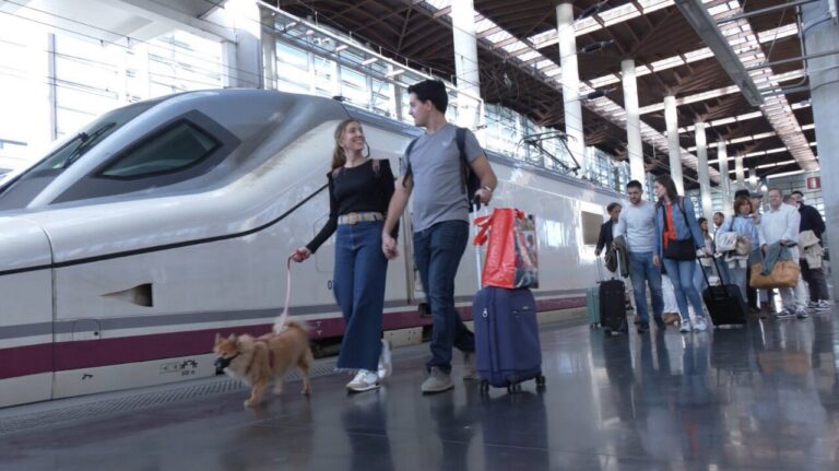 Pareja caminando con perro en estación de tren Renfe
