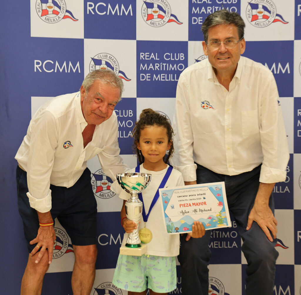 Niño sosteniendo un trofeo en la entrega de premios del Real Club Marítimo de Melilla