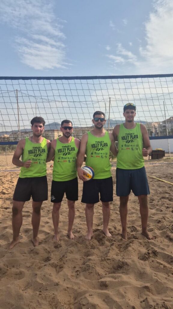 Cuatro jugadores de voleibol en la playa de San Lorenzo durante un torneo
