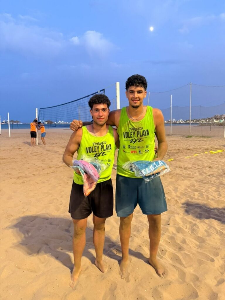 Jugadores celebrando en la playa tras el torneo de voleibol playa