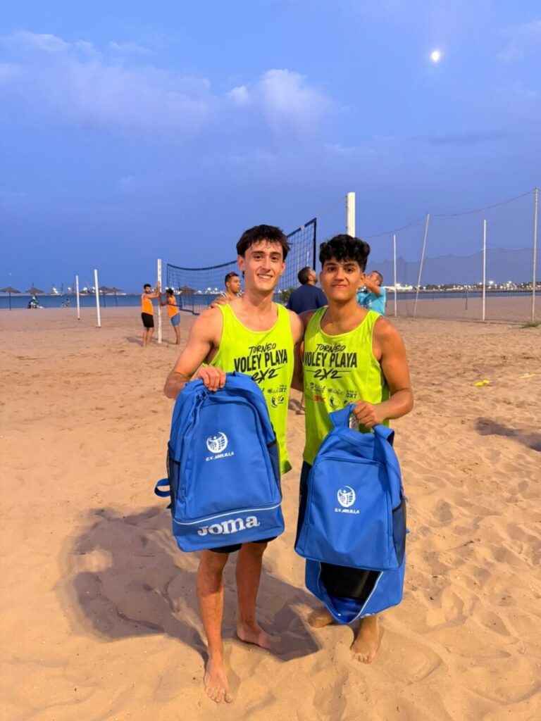 Jugadores de vóley playa con mochilas en la Playa de San Lorenzo