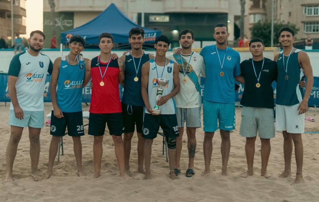 Grupo de jugadores de balonmano playa con medallas y trofeo en Melilla