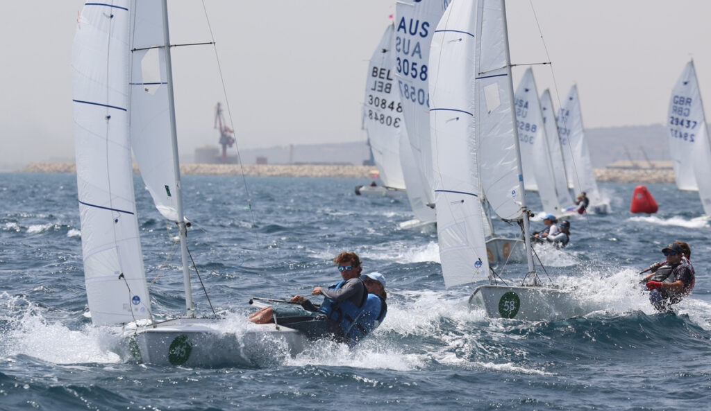 Regatistas compitiendo en un evento de vela con viento fuerte
