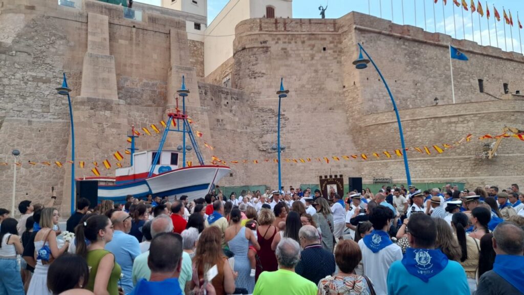 Numerosas personas en la procesión y ofrenda floral a la Virgen del Carmen