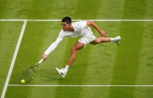 Carlos Alcaraz jugando tenis en una cancha de césped