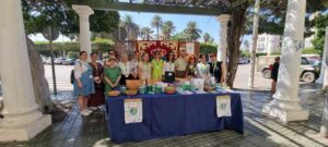 Grupo de personas en evento sobre Alzheimer con mesa informativa