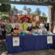 Grupo de personas en evento sobre Alzheimer con mesa informativa