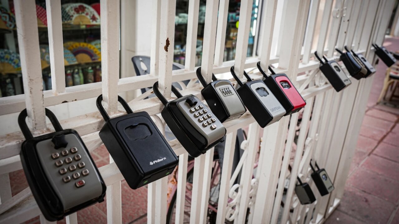 Varios candados de seguridad en una reja blanca