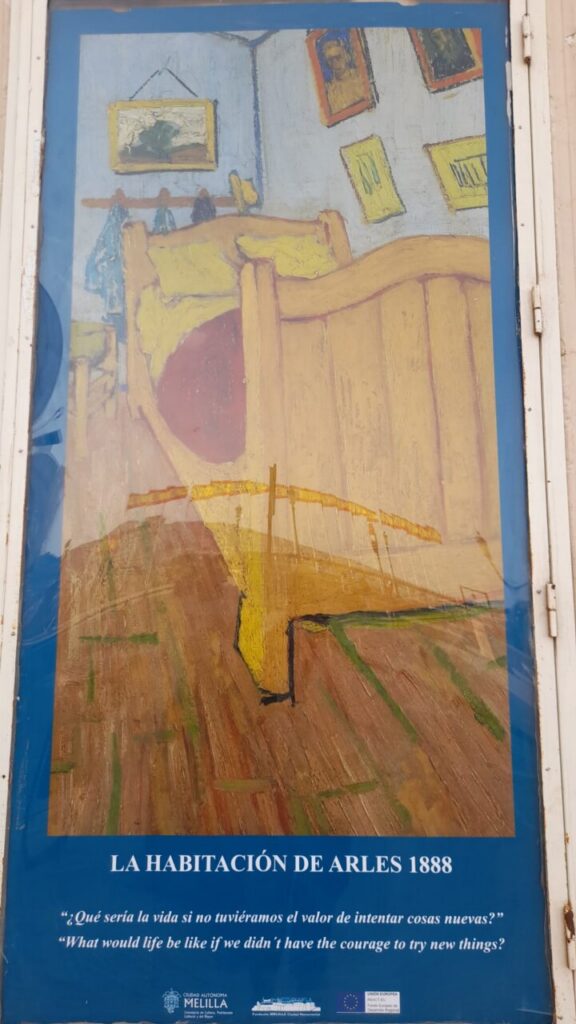 Poster reproducing Van Gogh's Bedroom in Arles: a yellow bed in a blue-walled room with framed pictures, captioned 'La habitación de Arles 1888'.