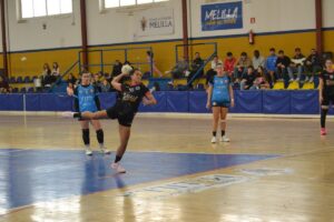 Jugadora de balonmano lanzando el balón en un partido