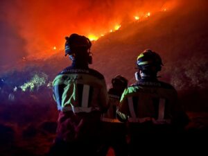 Bomberos de Melilla observando un incendio forestal en la noche