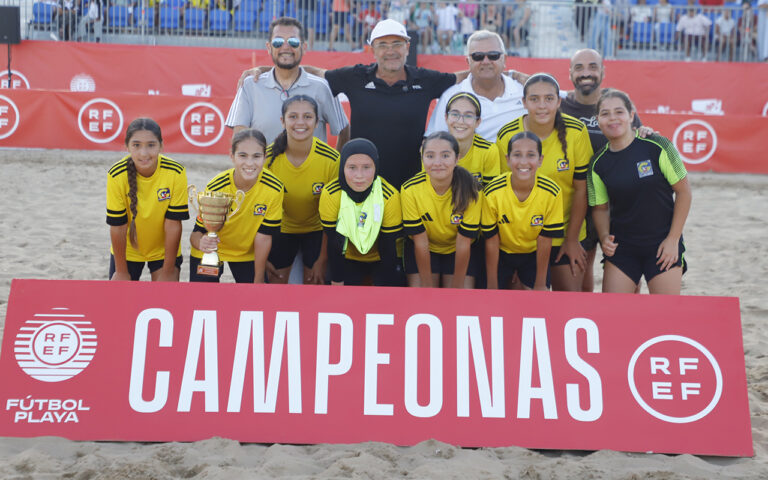 Equipo femenino infantil del Gimnástico Melilla con trofeo en la playa