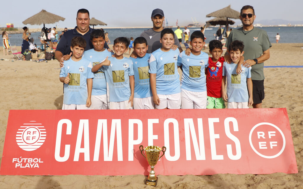 Equipo de fútbol playa benjamín del Melilla City con trofeo en la playa