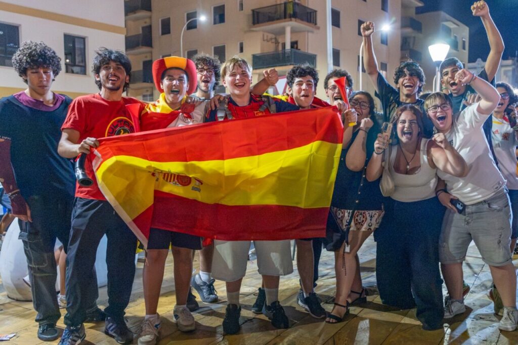 Grupo de jóvenes celebrando con la bandera de España tras la victoria en el Mundial