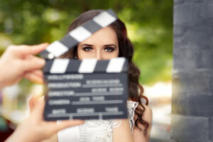 Mujer detrás de una claqueta de cine en un entorno al aire libre