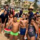 Grupo de niños y monitores en la playa durante el campamento de inglés.