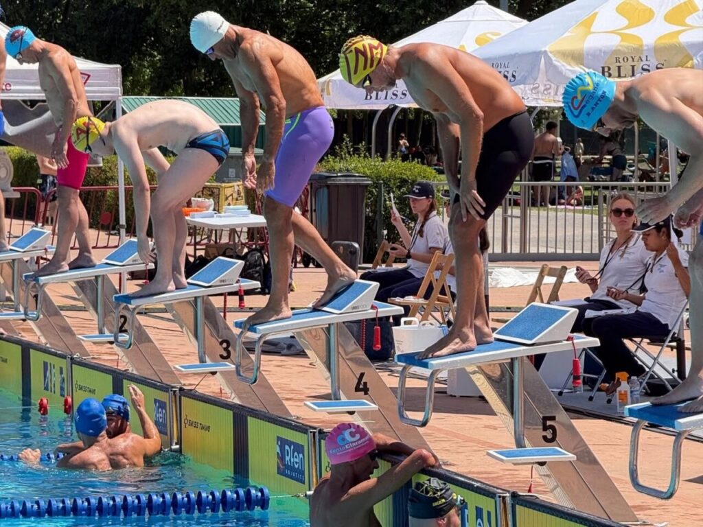 Nadadores en la competición de natación en Logroño, listos para saltar al agua.