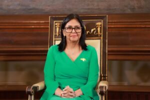 Delcy Rodríguez sentada en un sillón, vestida de verde.