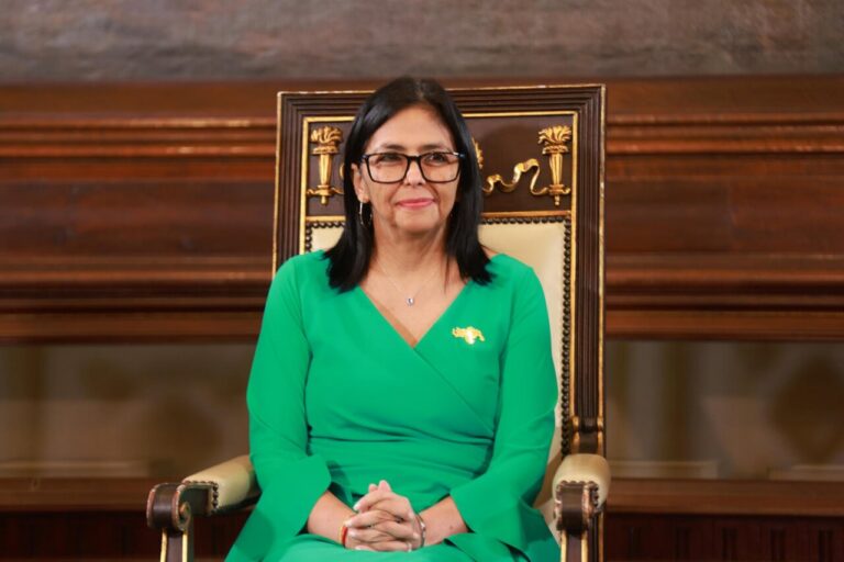 Delcy Rodríguez sentada en un sillón, vestida de verde.