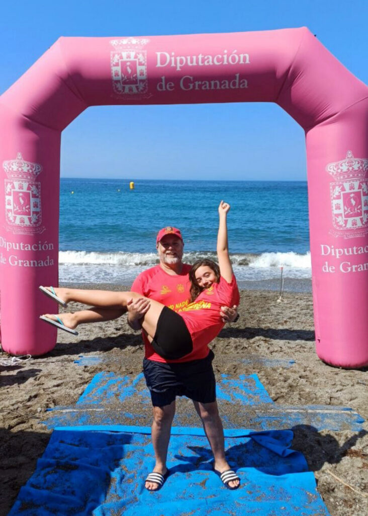 Elena Blasco celebrando con un hombre en la playa tras la carrera