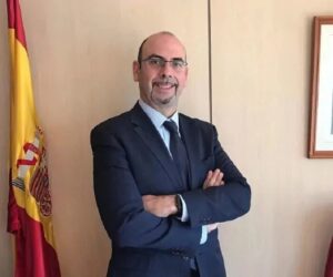 Fernando Germán Portillo en su oficina con bandera de España