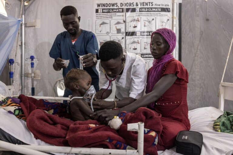 Médico atendiendo a un niño en un campo de refugiados en Chad