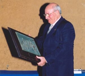 Pedro Botello sosteniendo un premio en un evento deportivo
