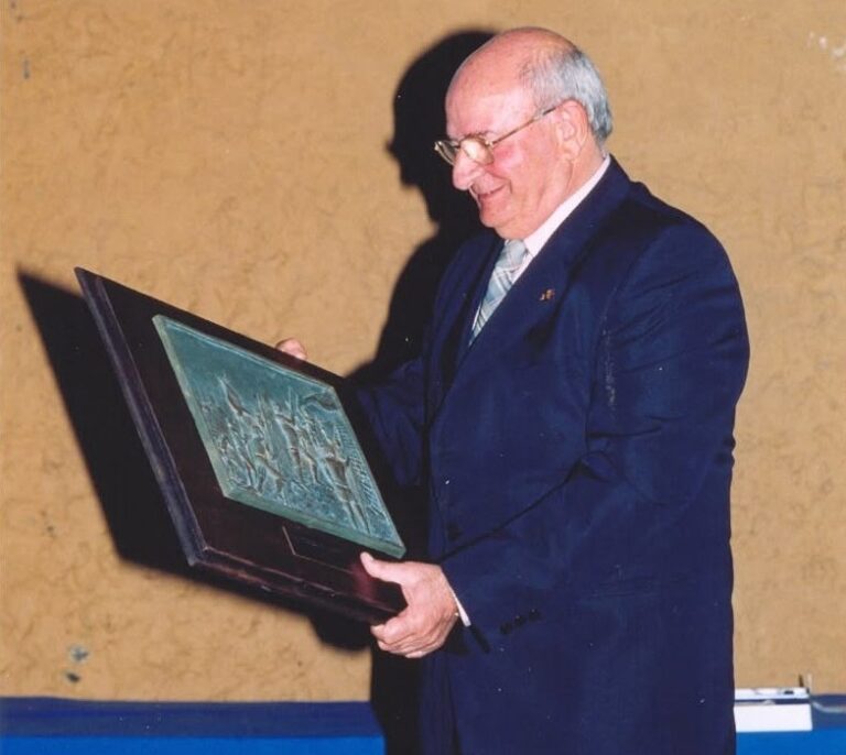 Pedro Botello sosteniendo un premio en un evento deportivo