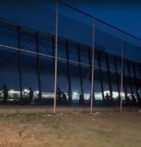 Imagen nocturna de la frontera en Melilla con inmigrantes