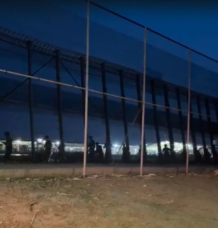 Imagen nocturna de la frontera en Melilla con inmigrantes