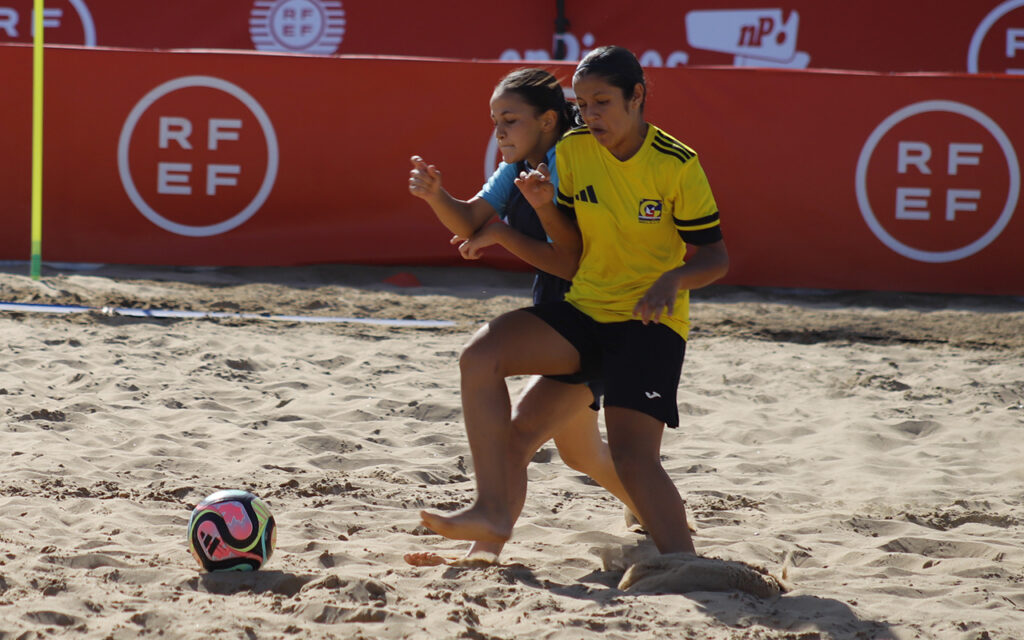 Jugadoras compitiendo en un partido de fútbol playa en la arena