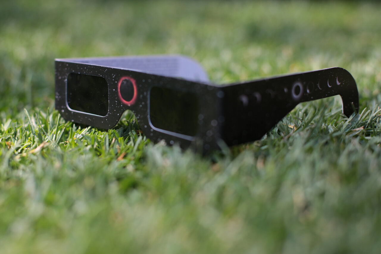 Gafas de seguridad para observar un eclipse solar sobre el césped