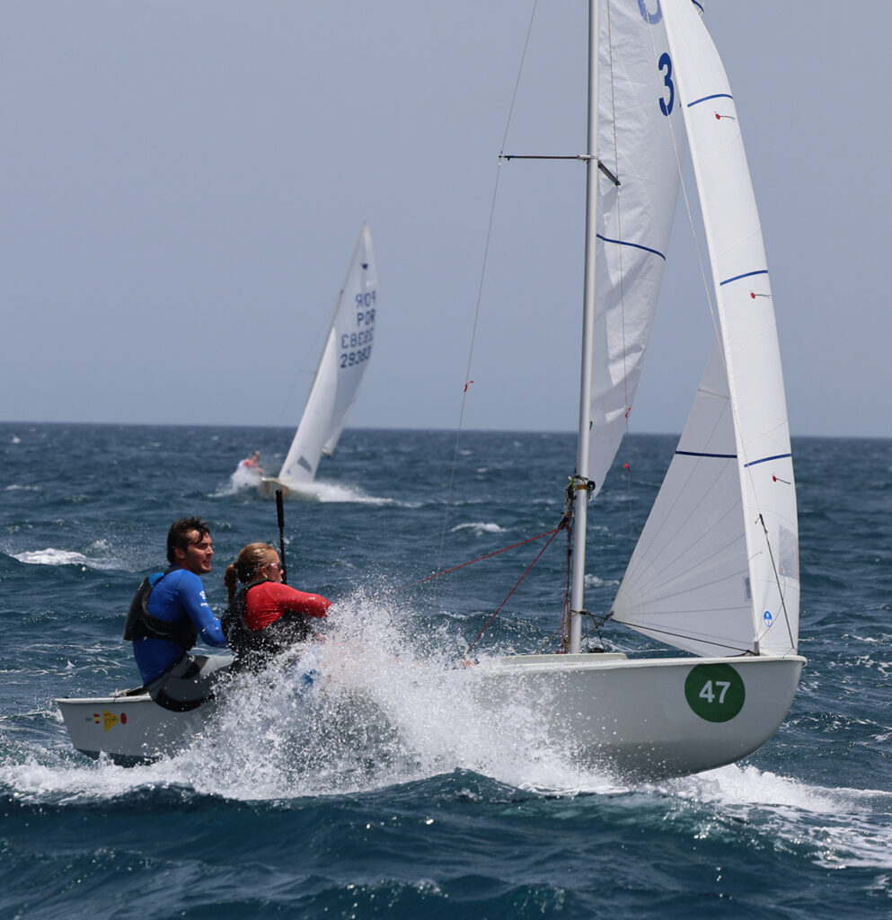 Regatistas compitiendo en condiciones de viento en el mar