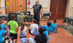 Un agente de la Guardia Civil explica a niños sobre su labor y equipos