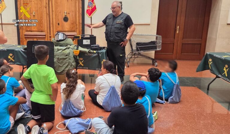 Un agente de la Guardia Civil explica a niños sobre su labor y equipos
