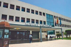 Fachada del Hospital Comarcal de Melilla con personas en la entrada