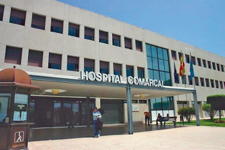Fachada del Hospital Comarcal de Melilla con personas en la entrada