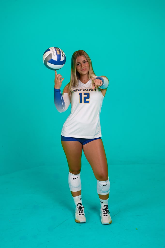 Juliana de Acharán posando con un balón de voleibol en un fondo azul