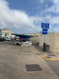 Marquesinas en el aparcamiento de taxis en la frontera con vehículos estacionados.