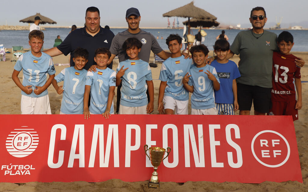 Equipo Melilla City A posando con el trofeo en la playa